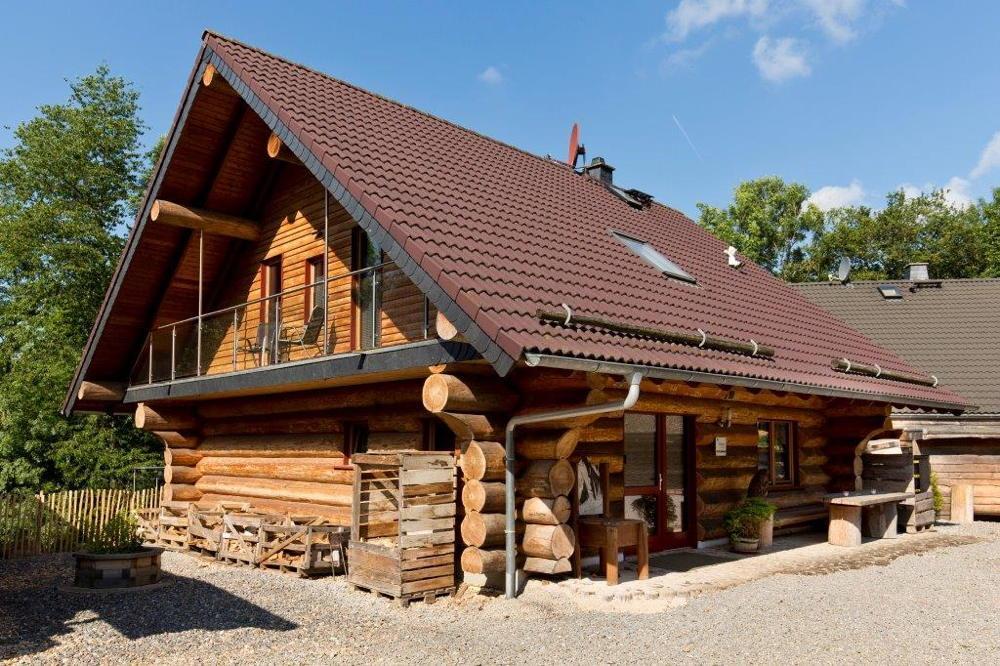 Das große Ferienhaus Biber ist ein Blockhaus aus Baumstämmen und sieht sehr rustikal aus.
